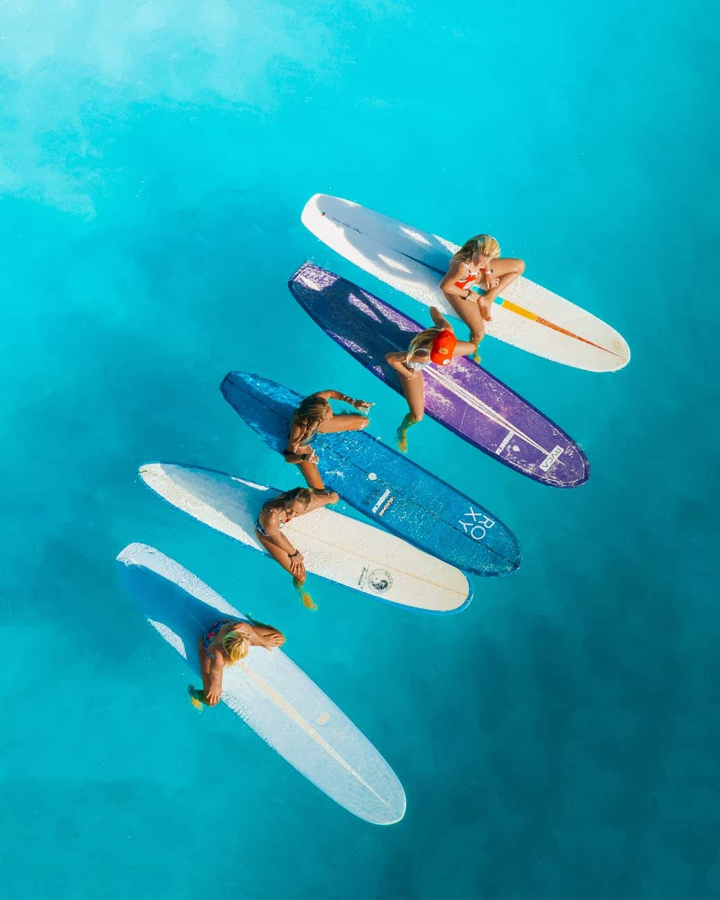 people riding on white and blue surfboard