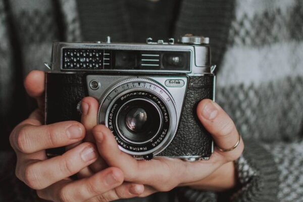 woman holdinng black analogue camera